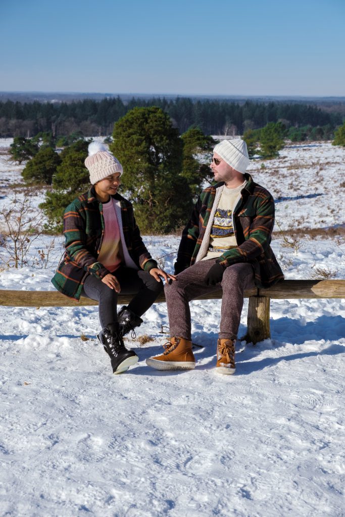 A Couple of men and women sitting in the snow during a cold winter day in the Netherlands
